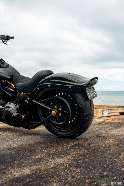 Black motorcycle parked on a road with a scenic background