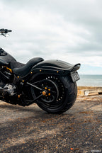 Black motorcycle parked on a road with a scenic background