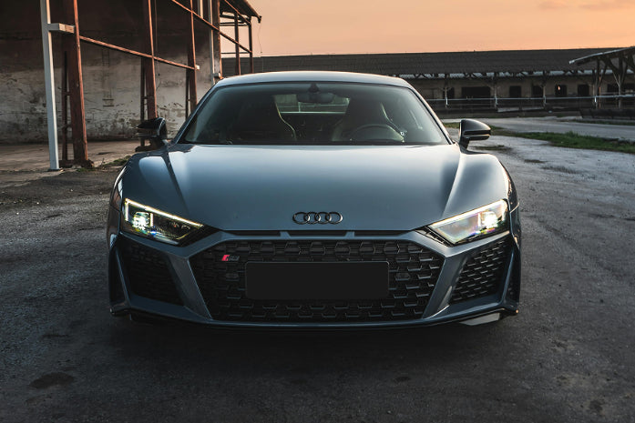 Audi car parked in an industrial area with a sunset sky.